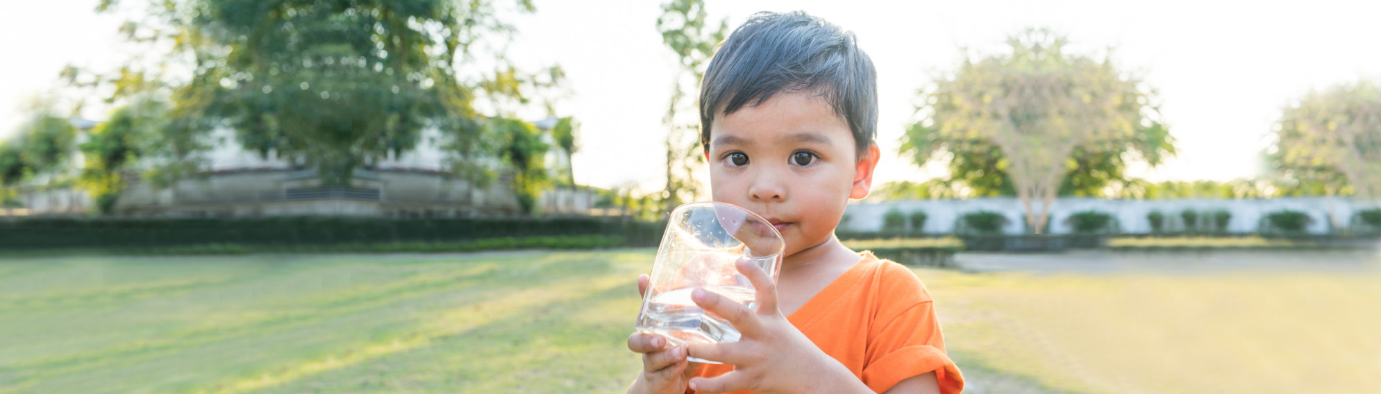 Asian boy holding a glass of water